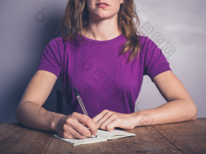 紫色记笔记的女人摄影图