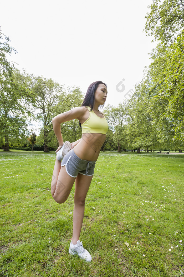 绿色调在草地中健身的女孩摄影图