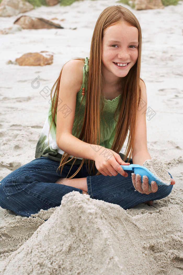 暗色调玩沙子的小女孩摄影图