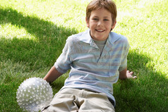 草地上玩球的小男孩