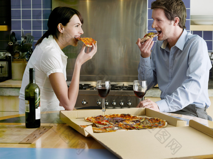 深色调吃比萨的夫妻摄影图