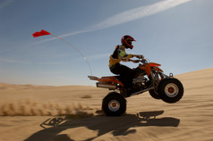 深色调沙漠中开摩托车摄影图