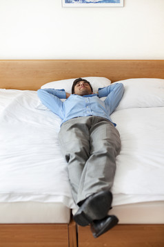 男性商人躺在酒店床上