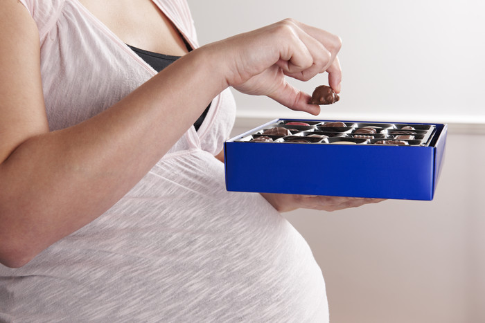 孕妇手捧盒子里的巧克力豆