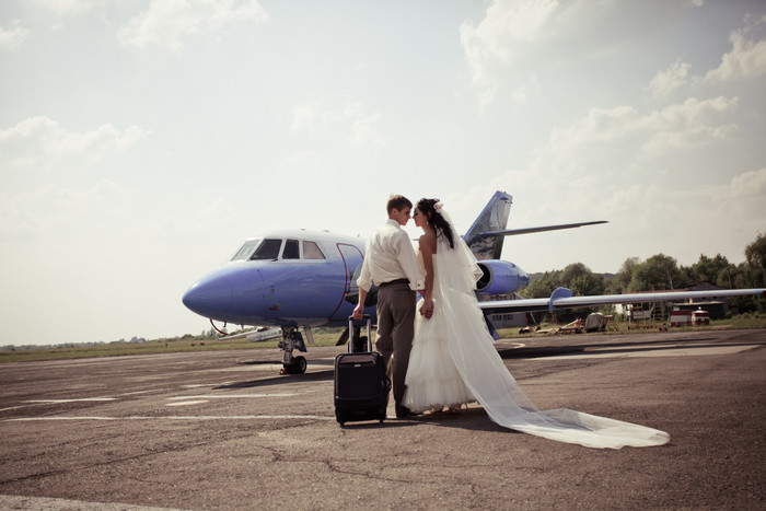 拉着行李坐飞机的婚礼夫妻