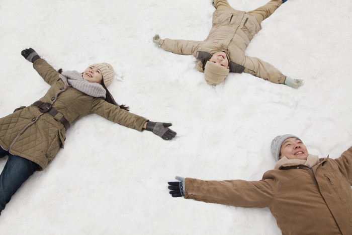 一家三口男人女人小孩家庭冬天躺着雪地上