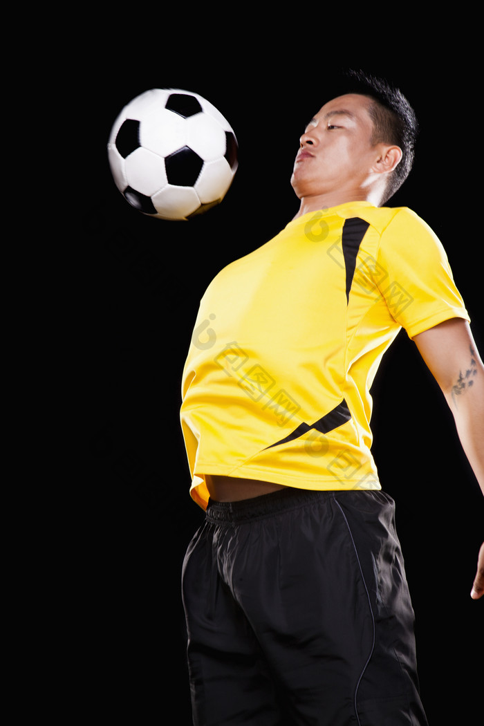 踢足球男子年轻的顶球体育运动员摄影图