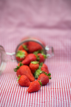 粉色调倒出的草莓摄影图