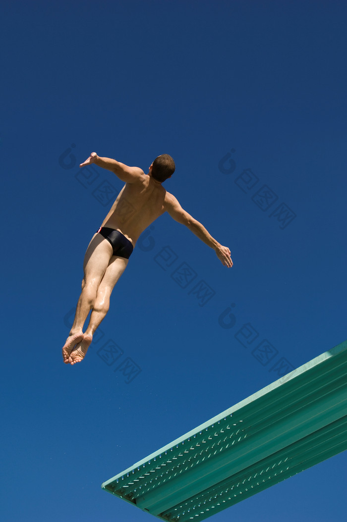 蓝色调高台跳水的人摄影图
