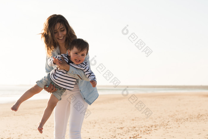 海滩上母亲抱着孩子玩耍