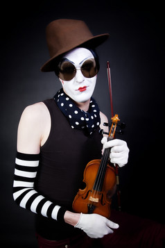 暗色玩小提琴的小丑摄影图