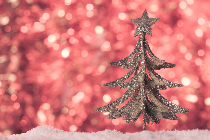 红色光斑背景前的圣诞树装饰