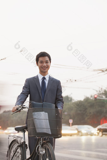 城市马路边男子西装革履推着自行车微笑乐观