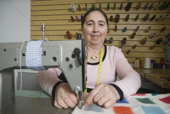 缝纫机做衣服的女人摄影图