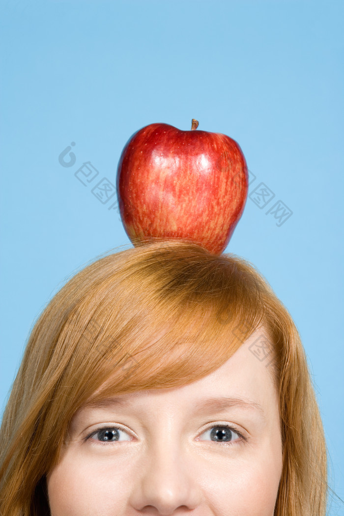 蓝色调顶苹果的女人摄影图
