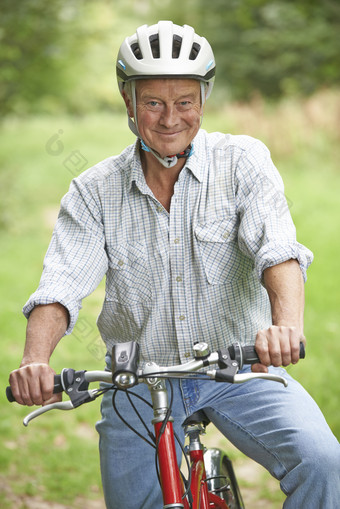 绿色调骑单车的老人摄影图