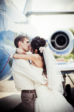直升机前亲吻的婚礼夫妻