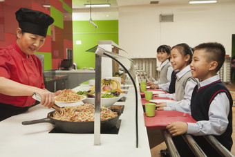 饭堂食堂小学生打饭午餐排队校服吃饭摄影图