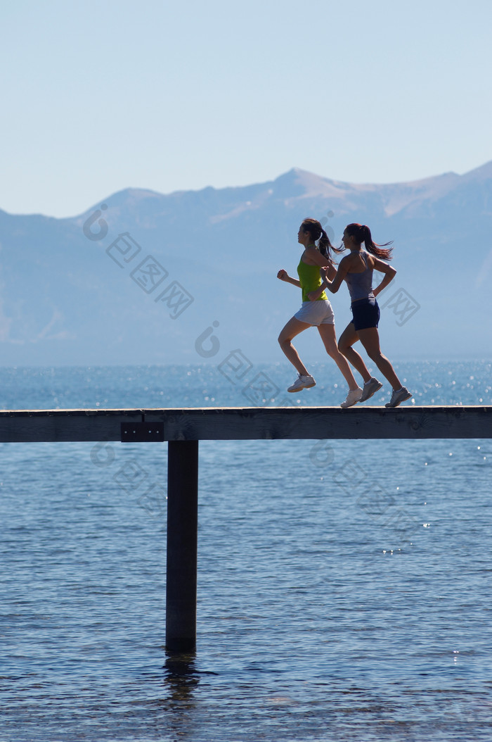蓝色调海上跑步的女孩摄影图