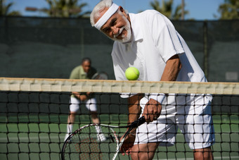 深色调在打网球的老人摄影图