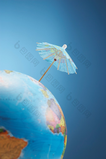 蓝色调地球仪上的小伞摄影图