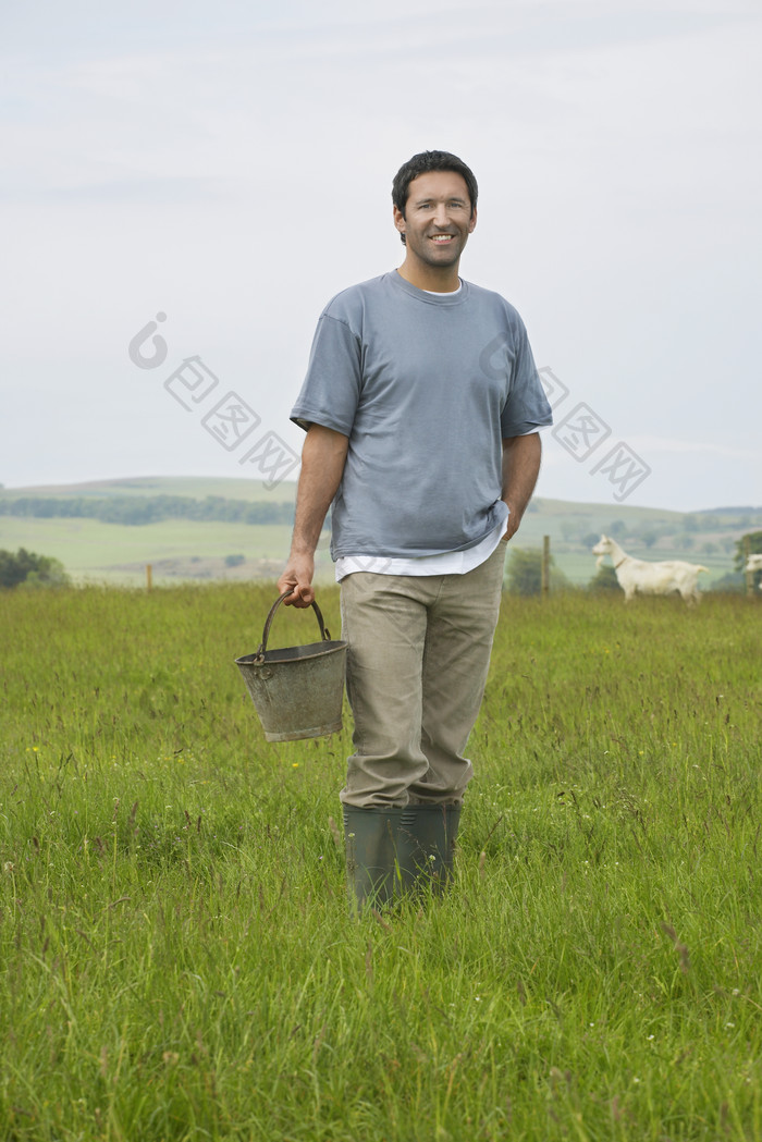清新草地中的农民摄影图