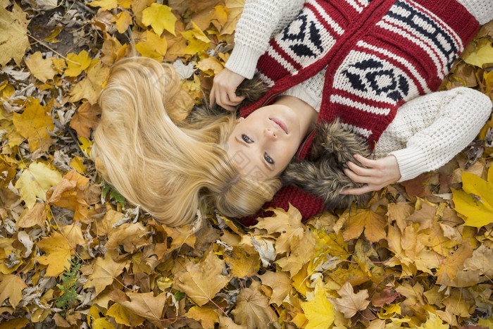 金发女孩躺在金色落叶上