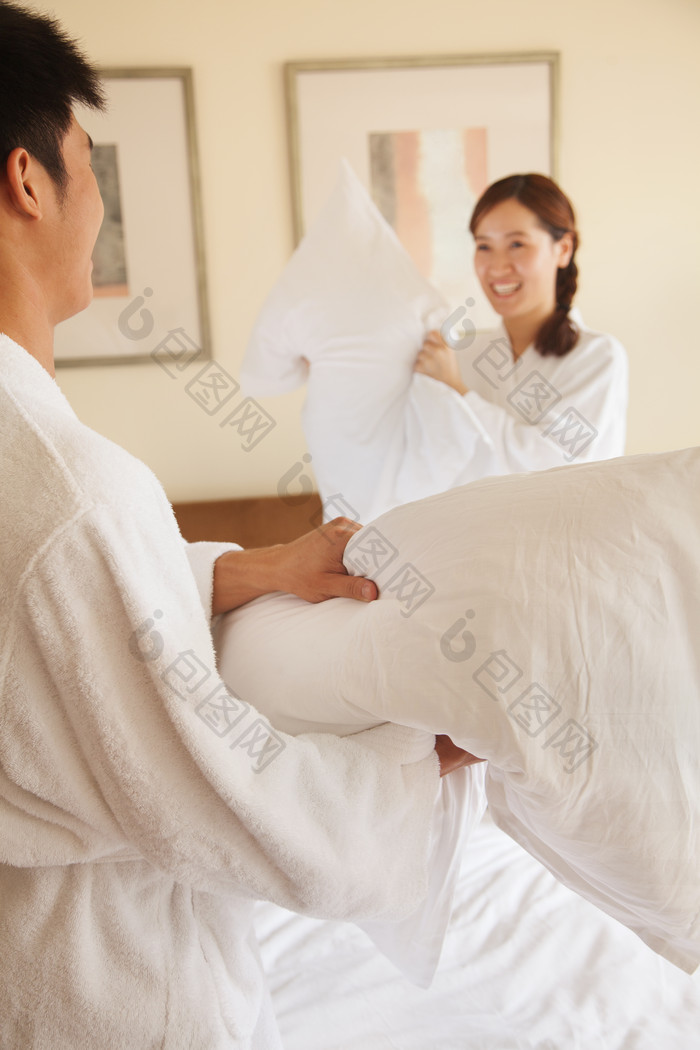 男人女人夫妻情侣酒店床上拿着枕头玩耍摄影