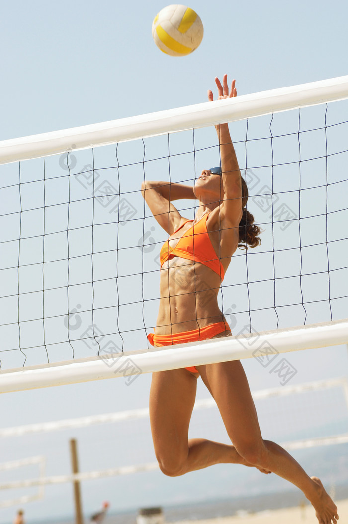跳跃打沙滩排球的女人