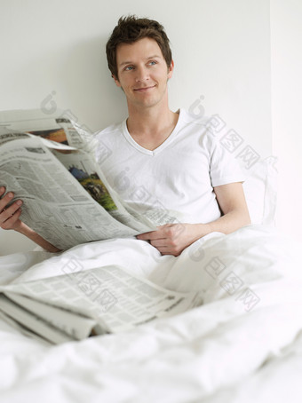 床上看报纸的男人