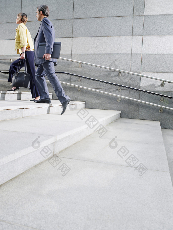 灰色调上台阶的商人摄影图