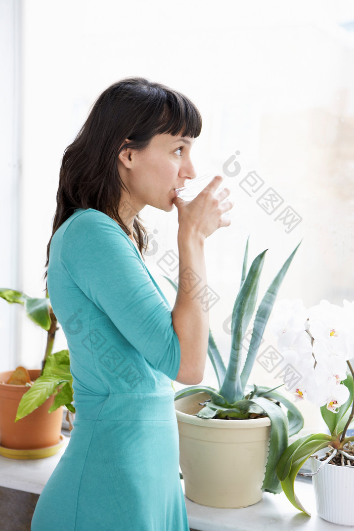 盆栽边喝水的女人