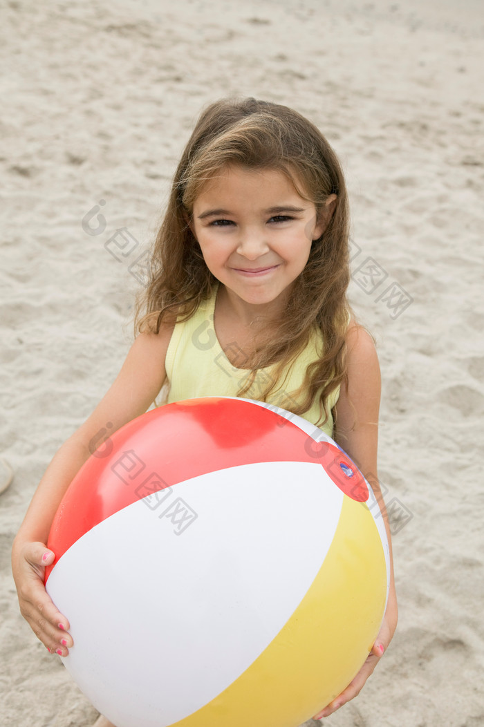在沙滩上玩皮球的女孩