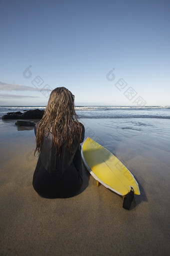 暗色调海边的冲浪女人摄影图