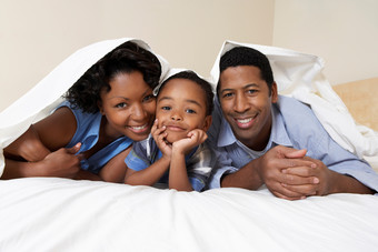 深色调在床上的家人摄影图