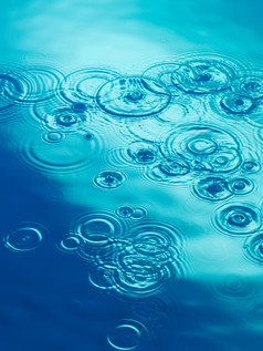 蓝色调水面的雨滴摄影图
