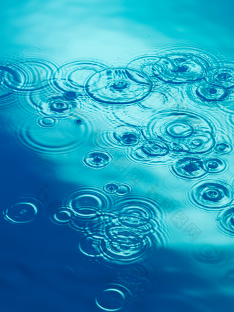 蓝色调水面的雨滴摄影图