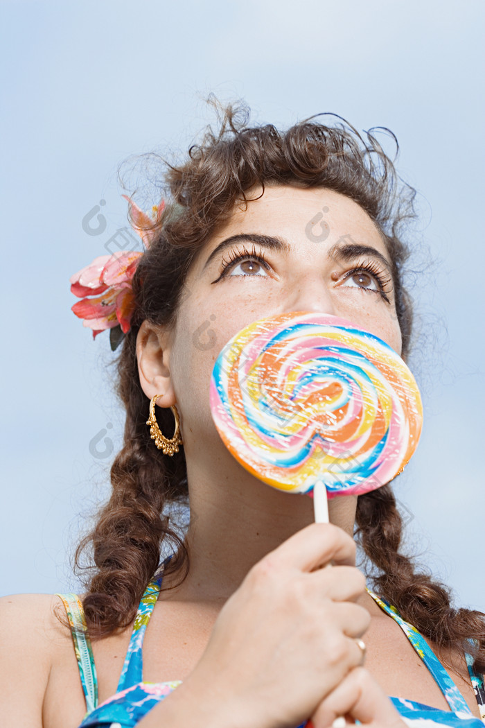 蓝色调吃棒棒糖的女孩摄影图