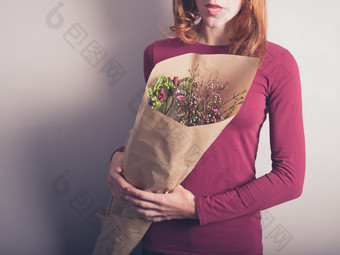 拿一束鲜花的女人摄影图