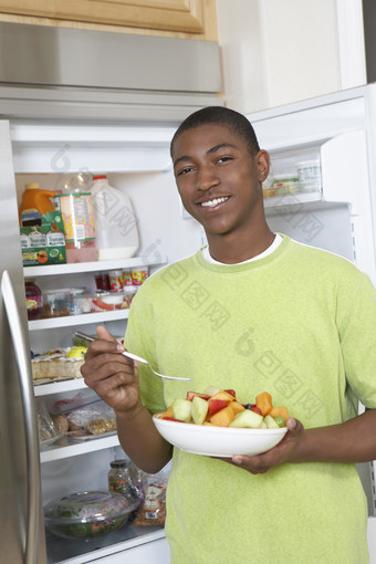 打开冰箱吃水果的男人
