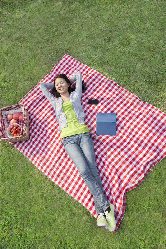 清新躺在草地上的女孩摄影图