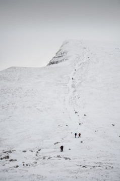 冬天爬雪山人物摄影图