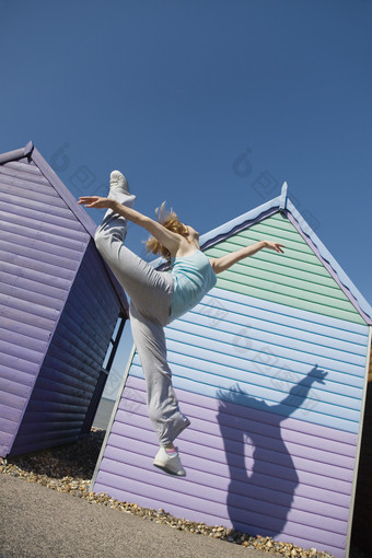 女人在彩色房子前跳跃