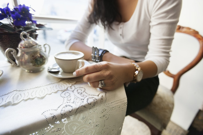 女性坐餐桌喝咖啡图片