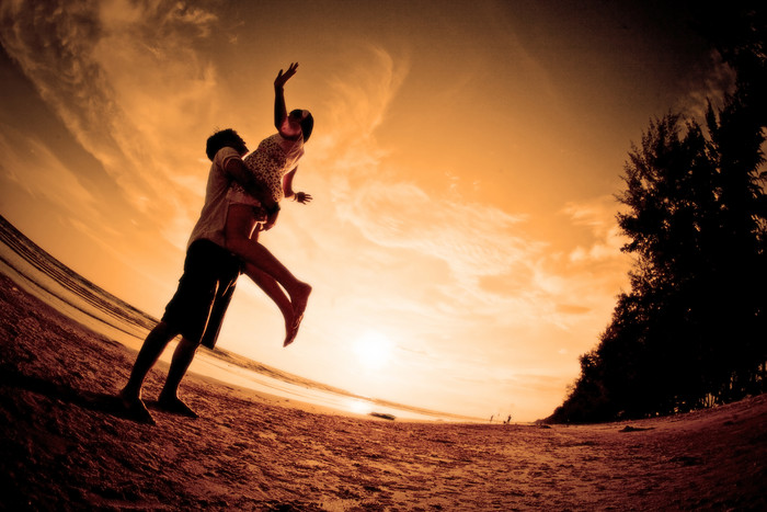 黄昏海滩边拥抱的情侣