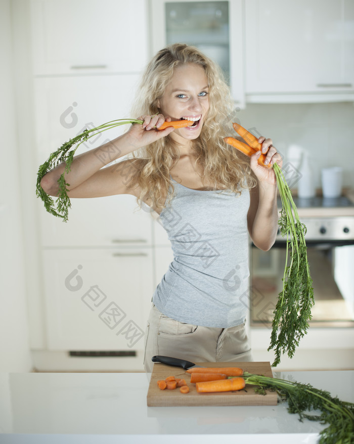 深色调吃胡萝卜的女孩摄影图