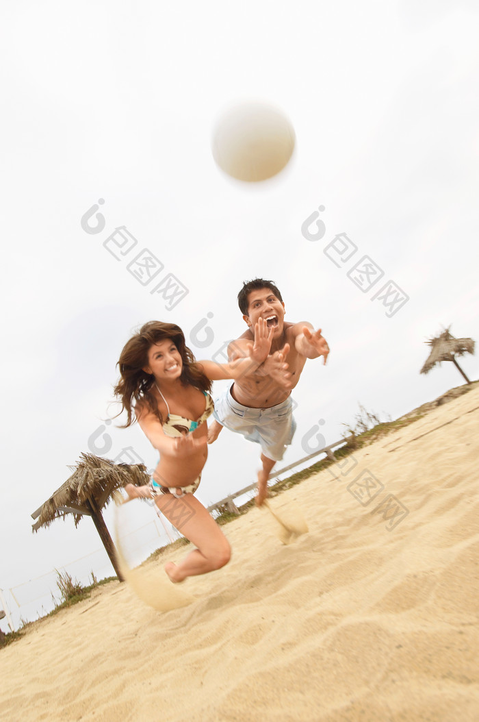简约玩沙滩排球的夫妻摄影图