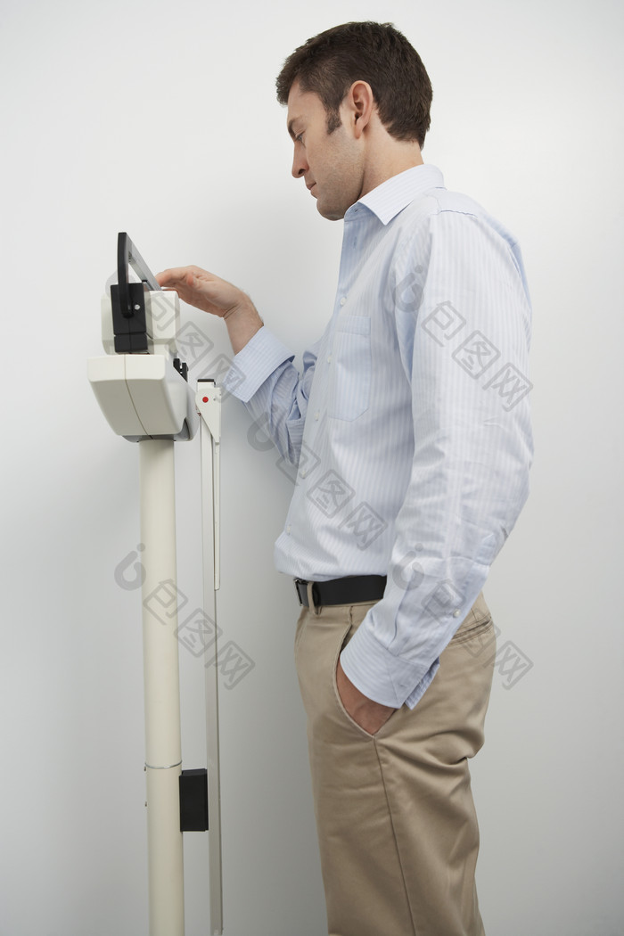 测量体重的男人摄影图