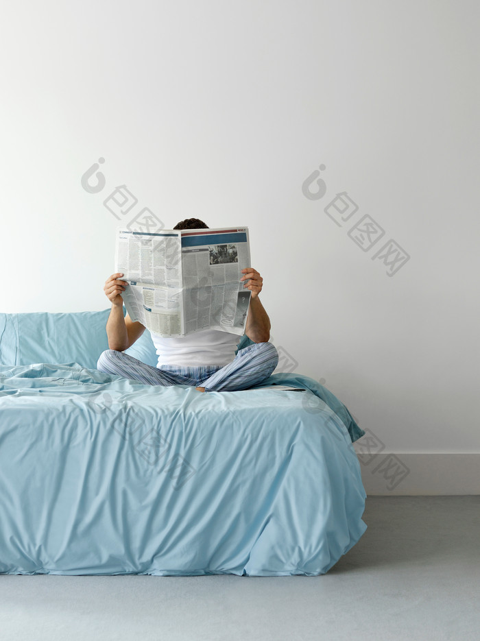坐床上看报纸的人物