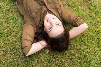 深色调躺草地上的女人摄影图